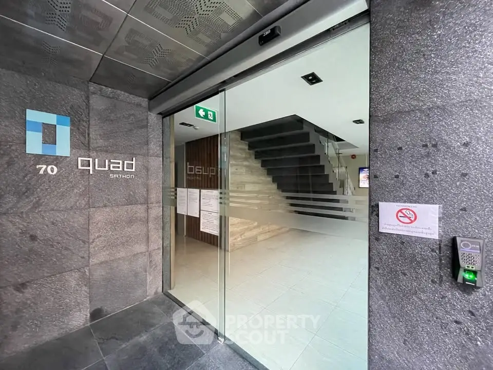 Modern building entrance with sleek glass doors and stylish interior design.