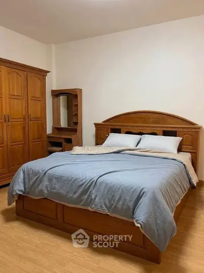 Spacious bedroom with elegant wooden furniture and cozy bedding