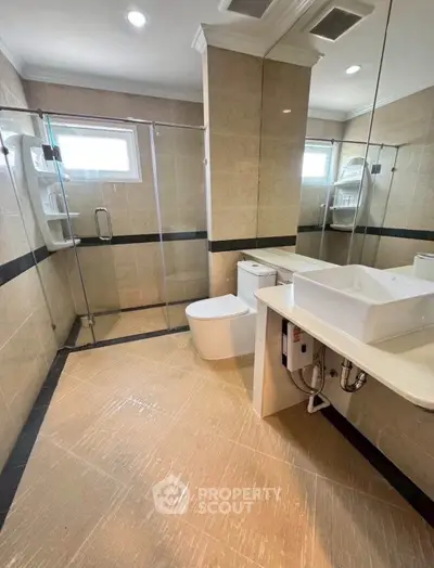 Spacious modern bathroom with glass shower and elegant fixtures