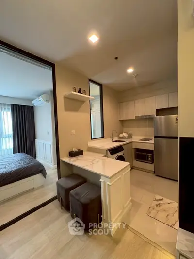 Modern open-layout kitchen with sleek appliances and cozy dining area in stylish apartment.
