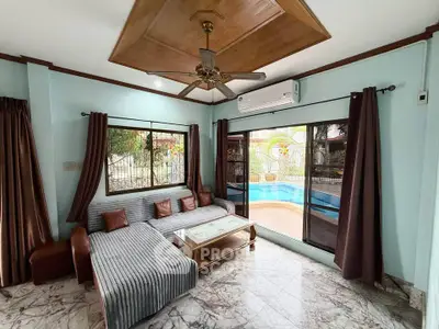 Spacious living room with pool view, modern furniture, and elegant ceiling fan.