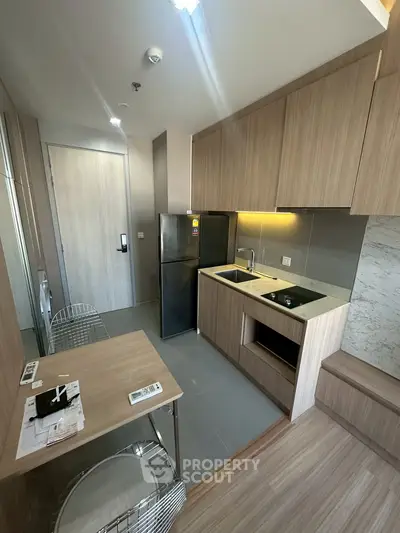 Modern kitchen with sleek cabinetry and compact dining area in a stylish apartment.