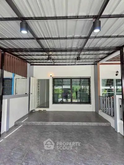 Spacious covered patio with modern lighting and tiled flooring