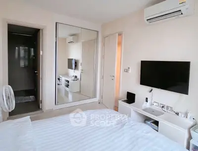 Modern bedroom with mirrored wardrobe and wall-mounted TV in stylish apartment