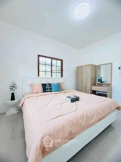 Cozy bedroom with modern decor and natural light, perfect for relaxation.