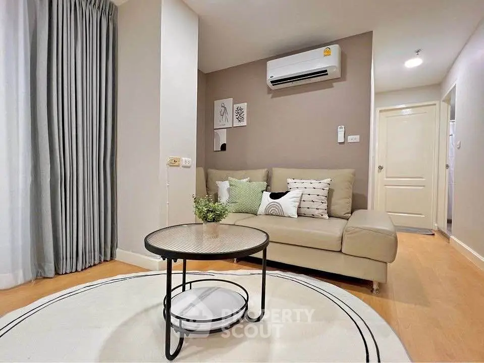 Modern living room with beige sofa, air conditioning, and stylish decor in a cozy apartment.