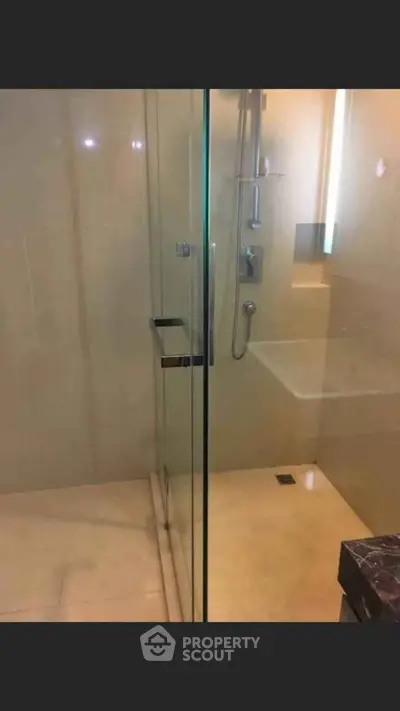 Modern bathroom with glass shower enclosure and sleek fixtures