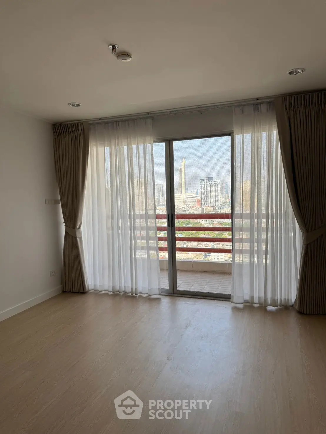 Spacious living room with large windows and city view