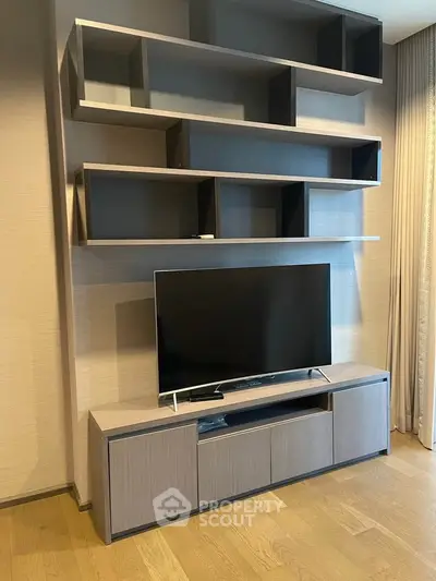 Modern living room with sleek TV stand and wall-mounted shelves, perfect for stylish urban living.