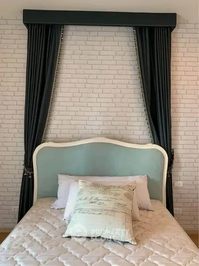 Charming bedroom with elegant headboard and stylish brick accent wall, perfect for cozy living.