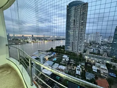Stunning high-rise balcony view overlooking river and cityscape at dusk, perfect for urban living.