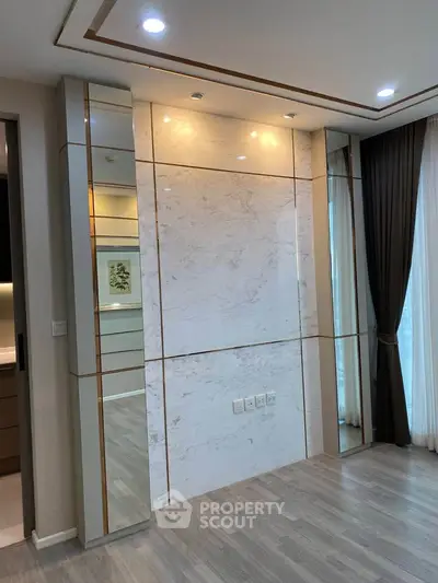 Modern living room with elegant marble accent wall and floor-to-ceiling windows.
