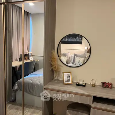 Cozy bedroom with modern decor and elegant mirror reflecting stylish design.