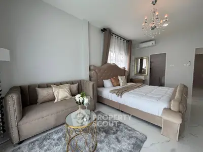 Luxurious bedroom with elegant decor, plush bed, and stylish sofa in a modern apartment.