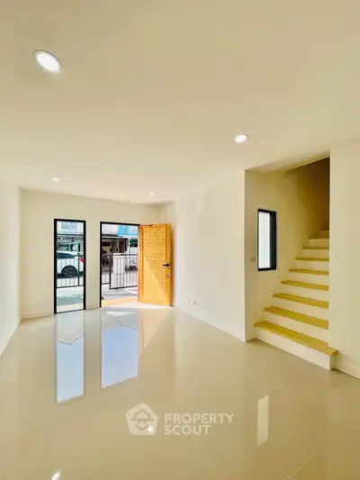Bright and spacious living room with modern staircase and natural light