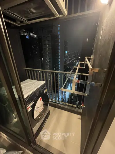 Modern high-rise balcony with city view and washing machine, perfect for urban living.