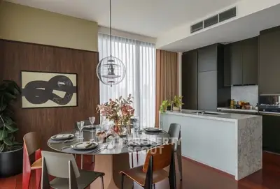 Modern dining area with stylish decor and open kitchen layout in luxury apartment.