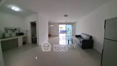 Spacious modern living room with sleek kitchen and balcony access