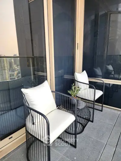 Stylish balcony with modern chairs and city view, perfect for relaxation and urban living.