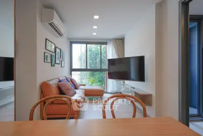 Modern living room with stylish decor and large window offering natural light.