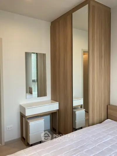 Modern bedroom with sleek wardrobe and stylish vanity in a cozy setting.