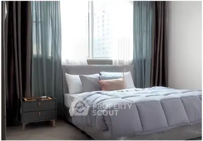 Modern bedroom with stylish decor and large window offering natural light.