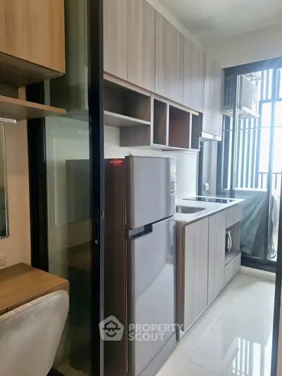 Modern kitchen with sleek cabinetry and stainless steel appliances in a stylish apartment.