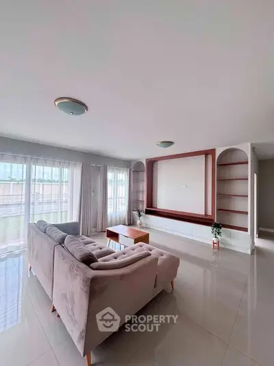 Spacious living room with modern decor and large windows offering natural light.