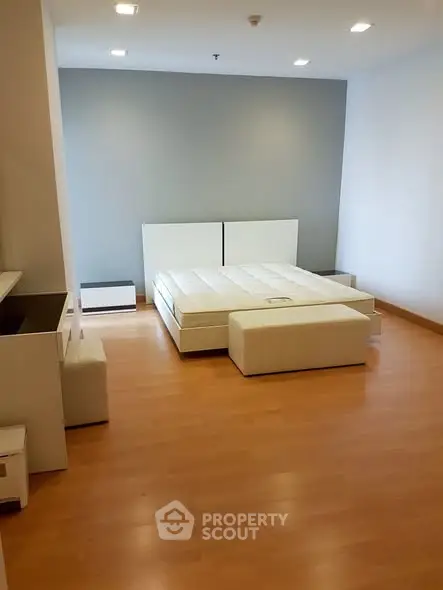 Spacious modern bedroom with minimalist design and wooden flooring