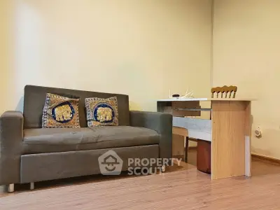 Cozy living room with stylish sofa and modern wooden desk, perfect for a comfortable home office setup.