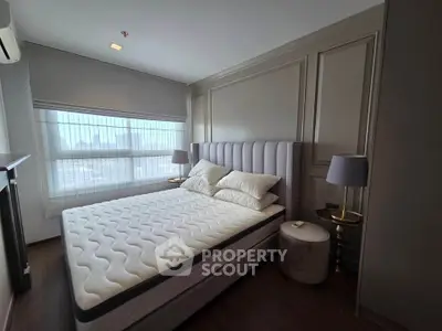 Luxurious bedroom with elegant decor and large window offering natural light.
