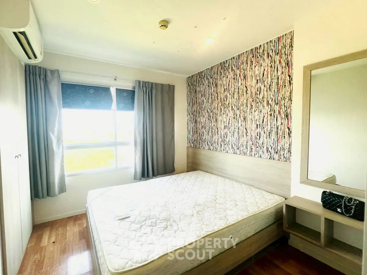 Bright bedroom with modern decor and large window, featuring a comfortable bed and stylish wallpaper.