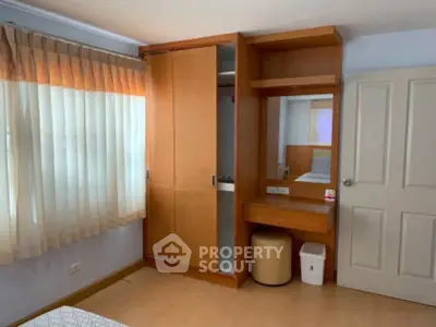 Cozy bedroom with built-in wardrobe and natural light from large window