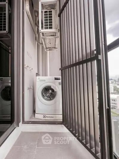 Compact balcony with washing machine and city view, ideal for urban living.
