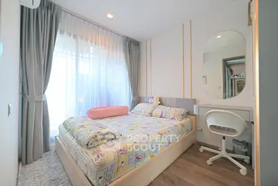 Charming bedroom with modern decor and natural light, featuring a cozy bed and stylish vanity area.