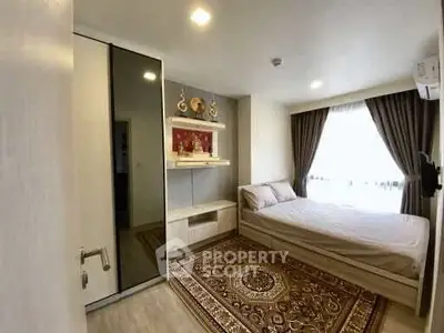 Cozy bedroom with elegant decor and ample natural light, featuring a stylish rug and modern furnishings.