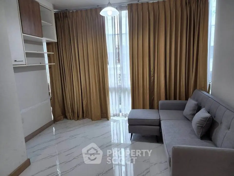 Modern living room with elegant curtains and stylish gray sofa on glossy tiled floor.