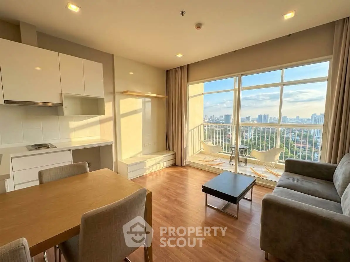 Spacious living room with stunning city view and modern furnishings in a high-rise apartment.