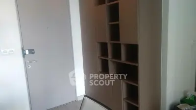 Modern interior with sleek wooden storage unit and minimalist door design.
