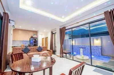 Luxurious open-plan living room with pool view, modern furniture, and elegant lighting.