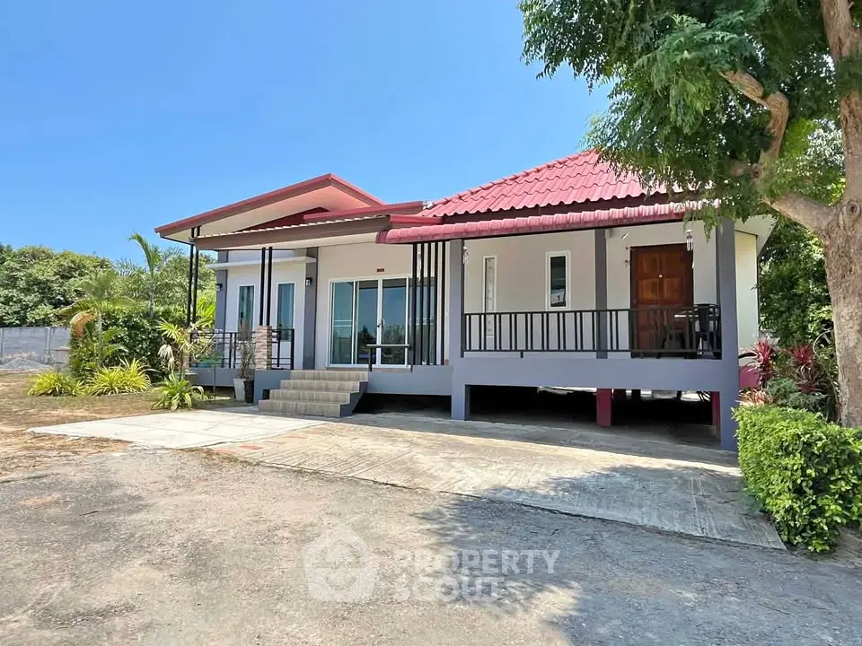 Charming modern house with red roof and spacious front yard, perfect for family living.