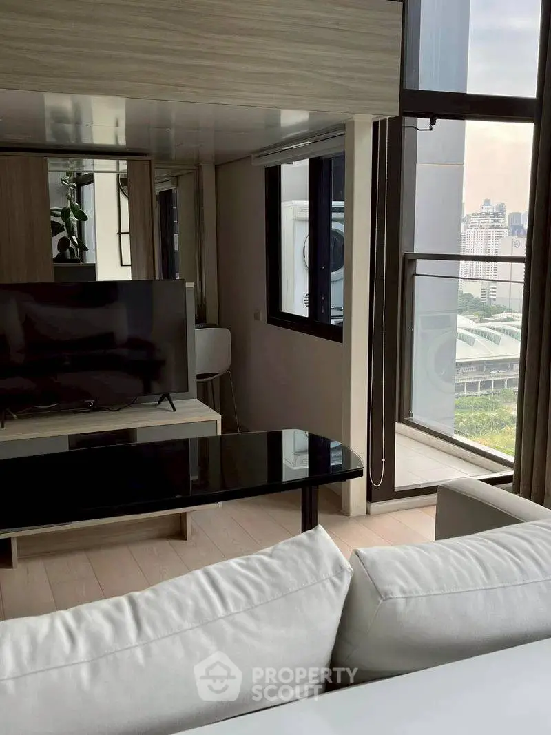 Modern living room with sleek furniture and city view balcony