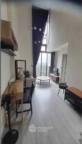 Modern living room with high ceiling and balcony view in stylish apartment.