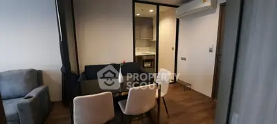 Modern living room with dining area and open kitchen in stylish apartment.