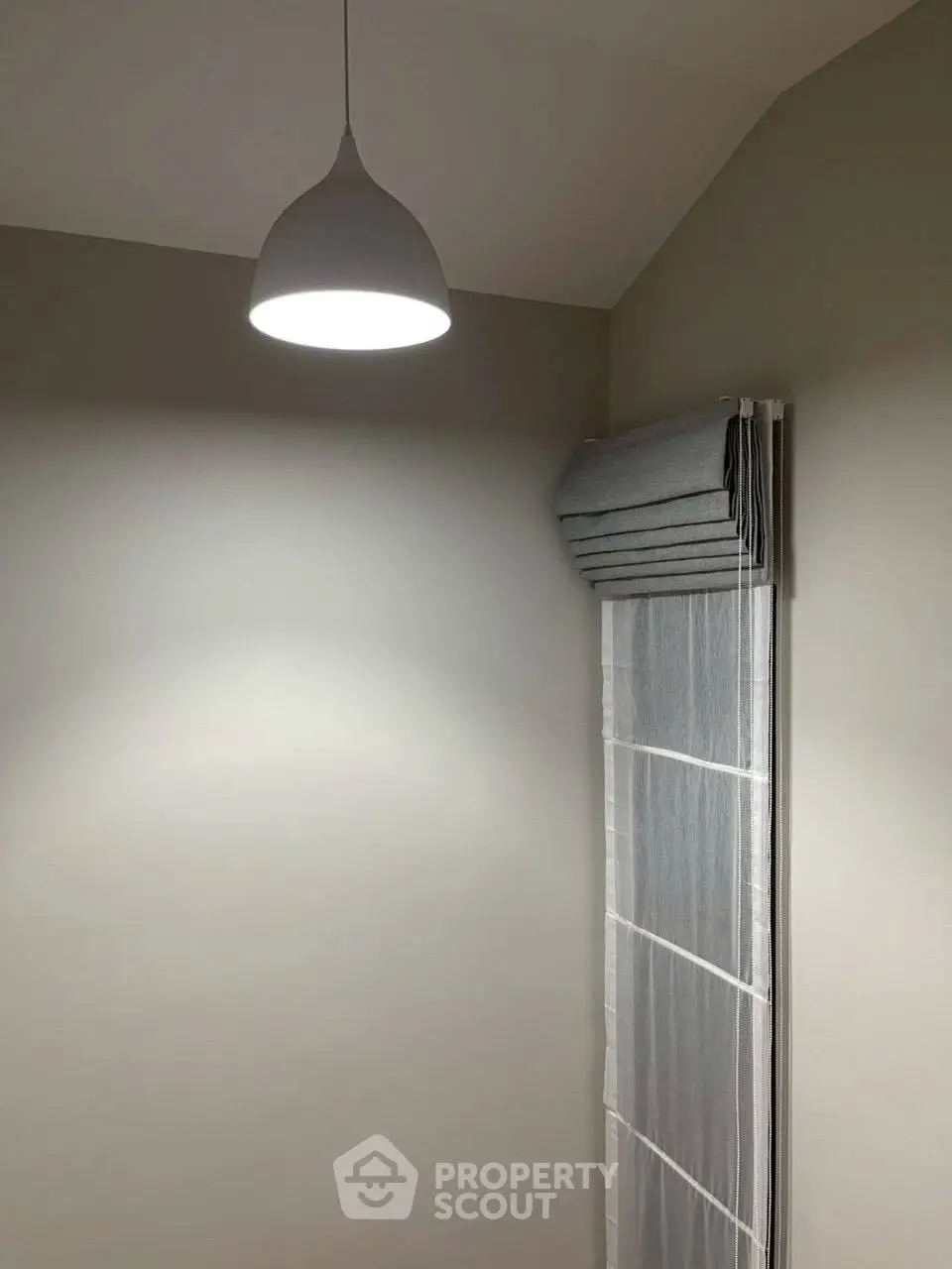 Minimalist interior with modern pendant light and sleek window blinds