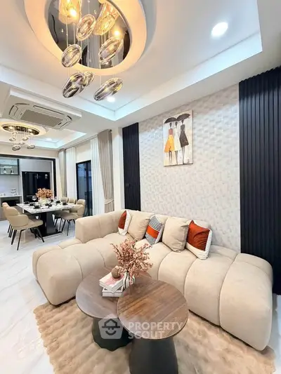 Luxurious modern living room with elegant decor and open dining area, featuring plush sofa and stylish lighting.