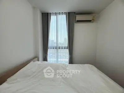 Bright bedroom with large window and city view, featuring air conditioning and modern decor.