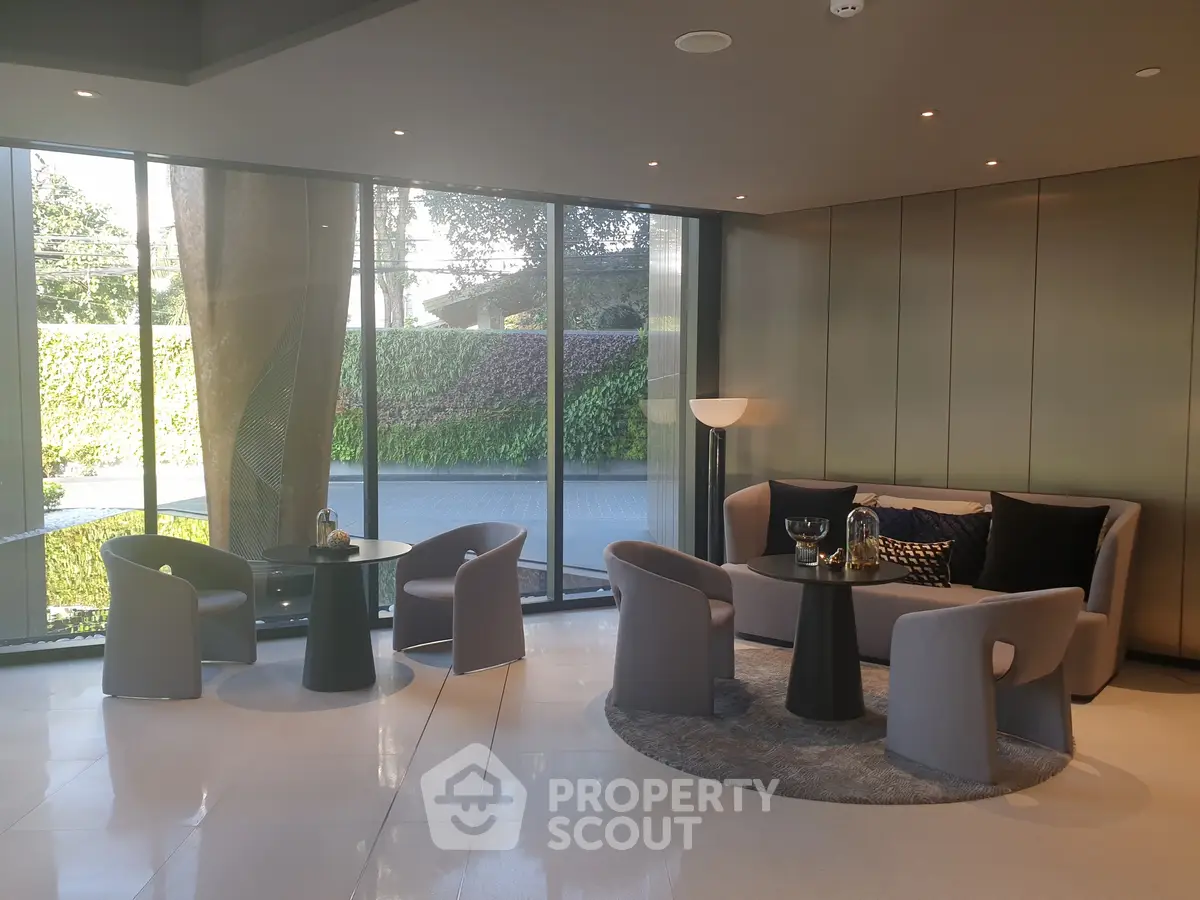 Modern living room with sleek furniture and large windows offering garden views.