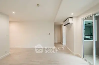 Spacious modern living room with air conditioning and sliding glass doors.