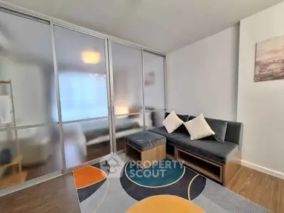 Modern living room with stylish furniture and colorful rug in a cozy apartment.